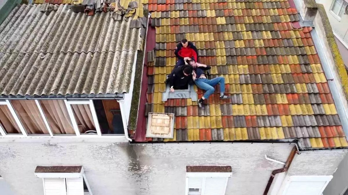 Balıkesir'de çatıya çıkan adamı polis ve itfaiye ekipleri indirdi